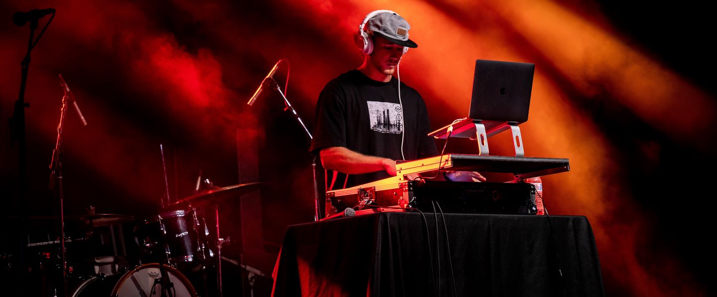 a studentDJ at a partyj lit in red lights at Hampden-Sydney College 