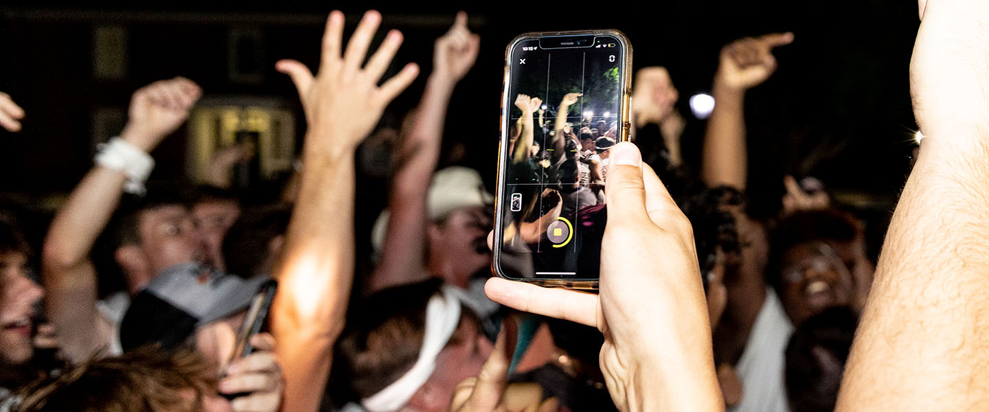Hampden-Sydney College students in a crowd from the perspective of a smart phone in the foreground